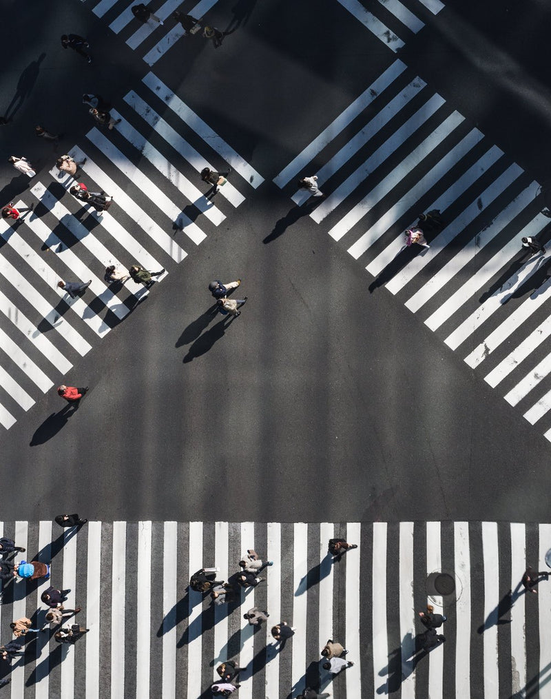 Intersection showing multiple directions of crosswalks with people crossing