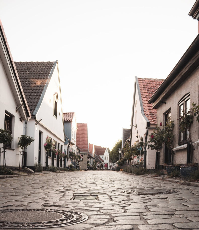View of a cobblestone street with homes reflecting similar architecture on both sides.